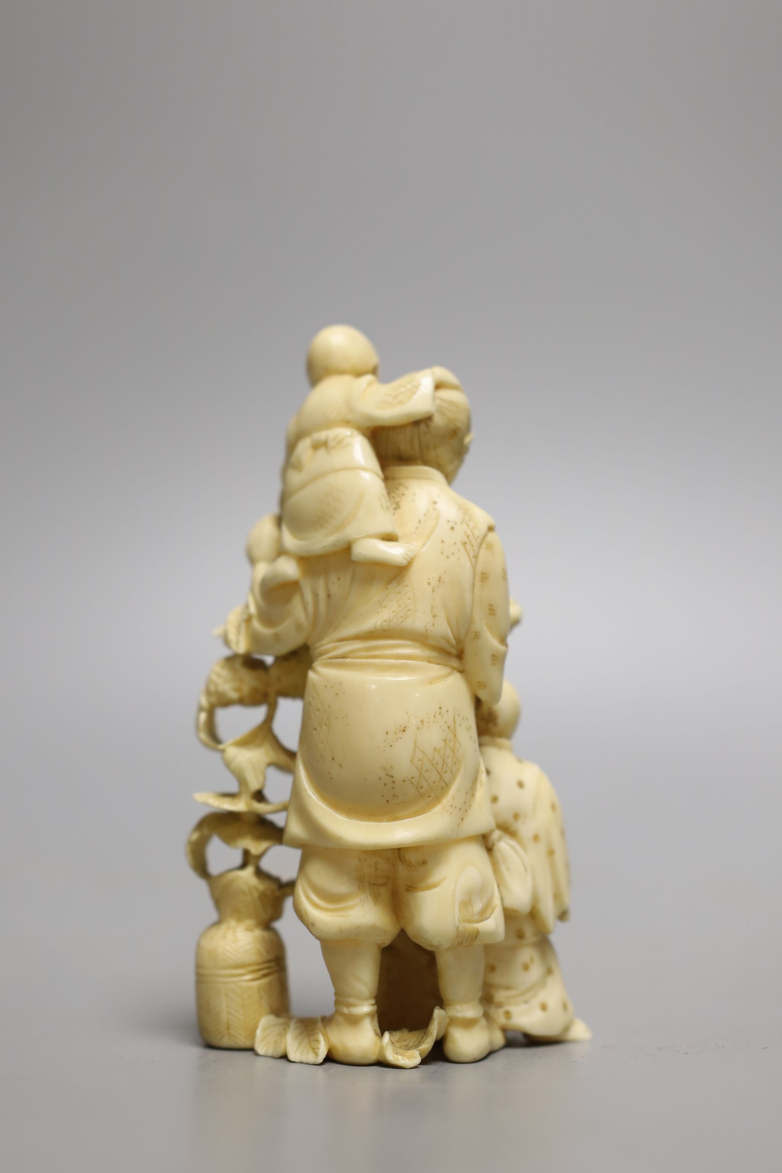 A Japanese carved ivory okimono of a farmer and two boys, Meiji period - 12.5cm tall